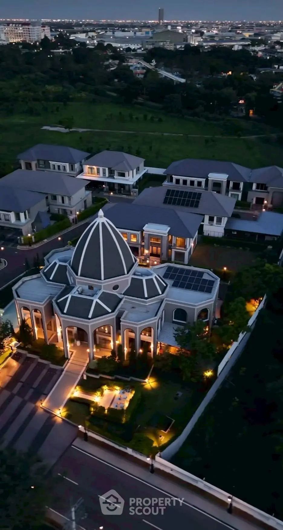 Luxurious mansion with unique dome architecture and stunning night lighting in a serene neighborhood.