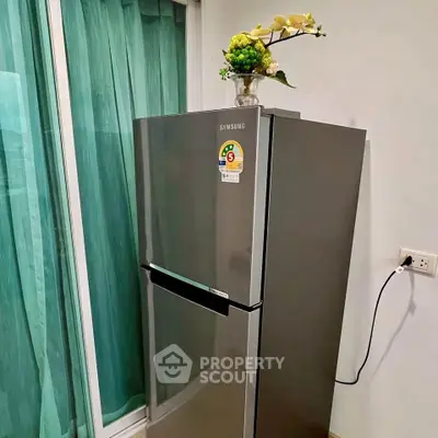 Modern kitchen with sleek Samsung refrigerator and decorative plant, perfect for contemporary living.