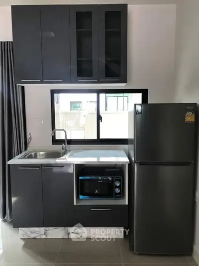 Modern kitchen with sleek cabinetry, stainless steel fridge, and built-in oven, perfect for urban living.