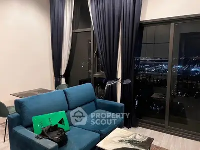 Luxurious living room with stunning night city view, elegant blue sofa, and chic decor.