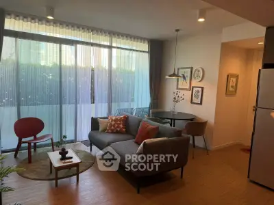 Modern living room with stylish decor and large windows offering natural light.