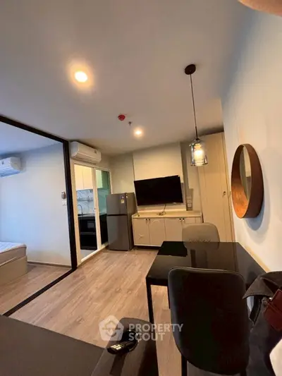 Modern living room with sleek furniture and open layout, featuring a wall-mounted TV and stylish lighting.