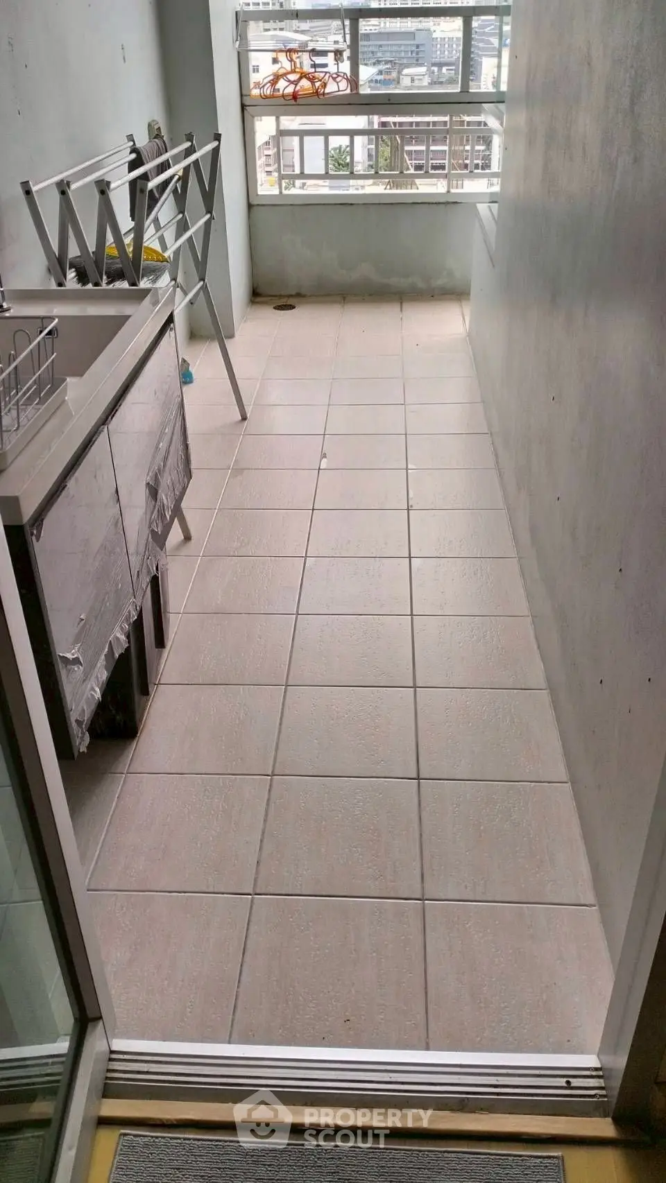 Spacious tiled balcony with city view, perfect for laundry and relaxation.