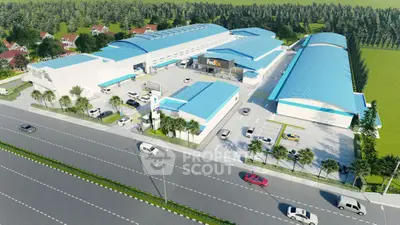 Aerial view of modern industrial complex with blue roofs and spacious parking area.