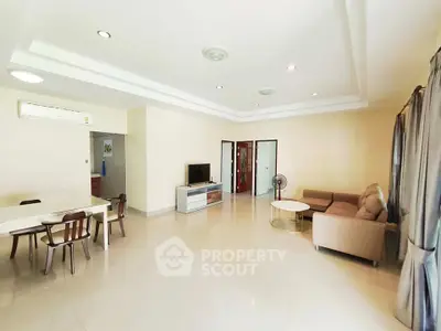 Spacious living room with modern furniture and ample natural light, perfect for family gatherings.