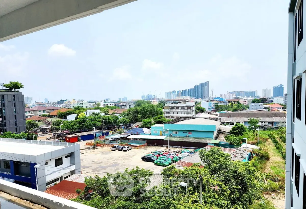 Stunning cityscape view from a modern apartment balcony, showcasing urban skyline and lush greenery.