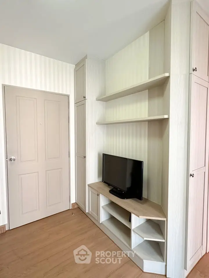 Modern living room with built-in TV cabinet and wooden flooring
