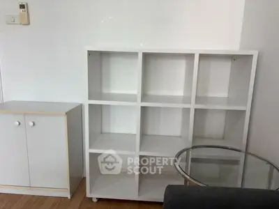 Minimalist interior with white shelving and glass table in modern apartment