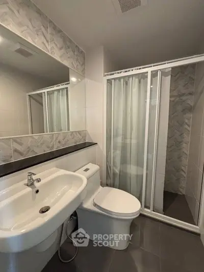 Modern bathroom with sleek design featuring a shower and elegant tile work.
