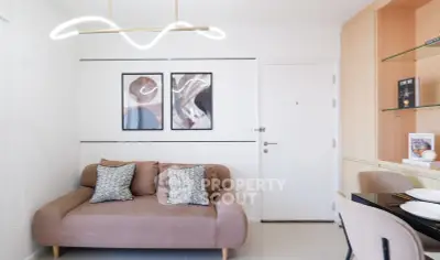 Modern living room with stylish sofa and wall art, featuring elegant lighting and built-in shelving.