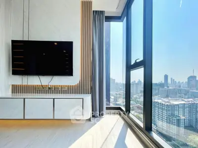 Modern living room with large windows offering stunning city views and sleek TV setup.