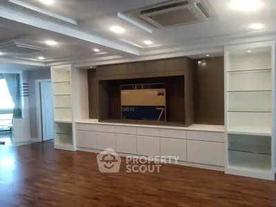 Spacious modern living room with built-in shelves and hardwood flooring, perfect for stylish living.