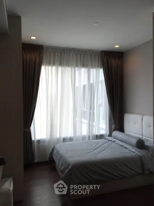 Cozy bedroom with large window and elegant curtains