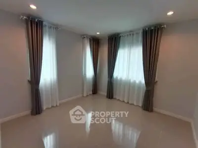 Spacious corner unit with elegant curtains and polished tile flooring, perfect for modern living.