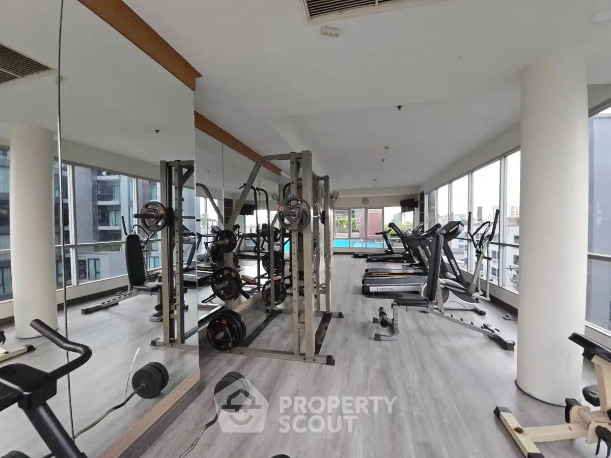Spacious modern gym with state-of-the-art equipment and panoramic city views.