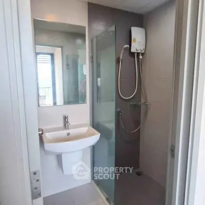 Modern bathroom with glass shower and sleek fixtures in a contemporary apartment.