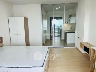 Modern bedroom with glass partition and view into sleek kitchen area