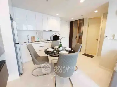 Modern kitchen with sleek white cabinets and dining area in a stylish apartment.