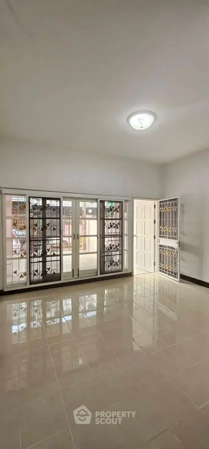 Spacious empty room with large windows and glossy tiled floor, perfect for customization.