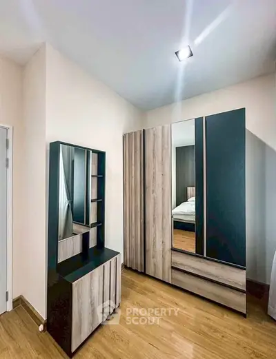 Modern bedroom with stylish wardrobe and dresser, featuring sleek design and ample storage space.