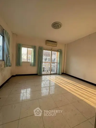 Spacious sunlit room with large windows and tiled flooring, perfect for customization.