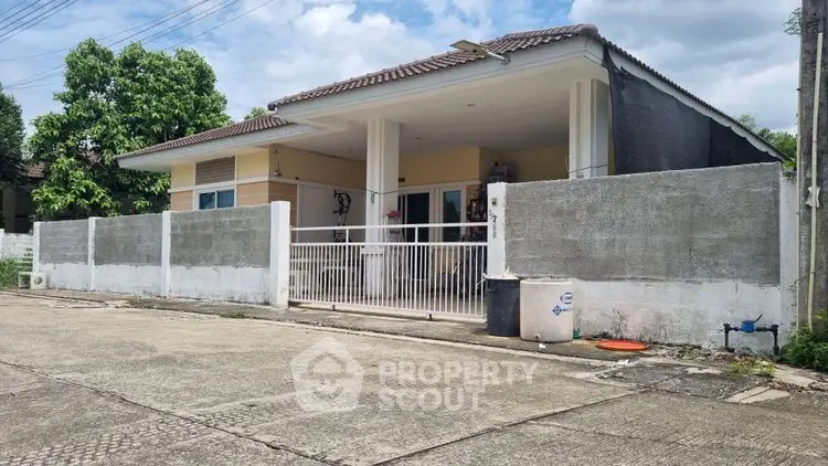 Charming single-story house with gated entrance and spacious driveway in a serene neighborhood.