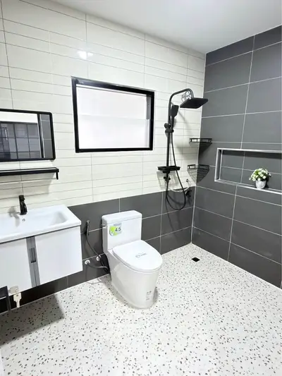 Modern bathroom with sleek fixtures and stylish tile design, featuring a shower and toilet.