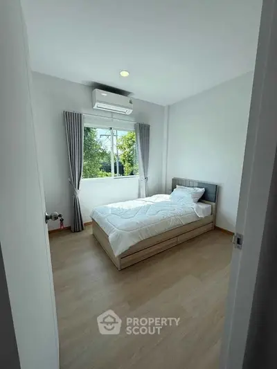Bright minimalist bedroom with large window and modern decor