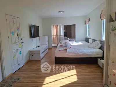 Bright and cozy bedroom with wooden flooring and modern furnishings