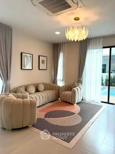 Elegant living room with plush seating and pool view, perfect for relaxation.