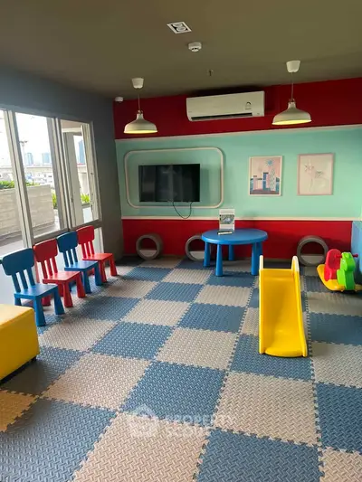 Vibrant children's playroom with colorful chairs, slide, and city view.