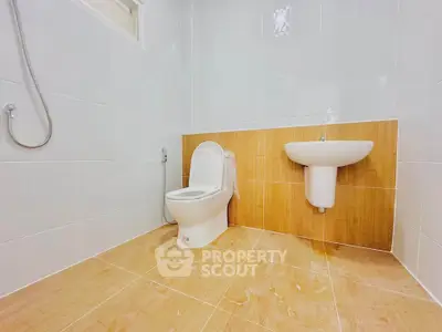 Modern bathroom with sleek design and elegant fixtures, featuring a toilet and wall-mounted sink.