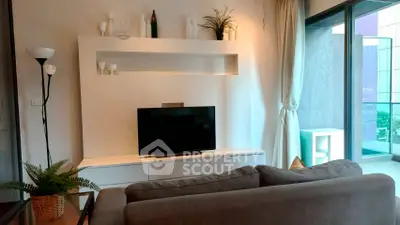 Modern living room with sleek TV setup and balcony view