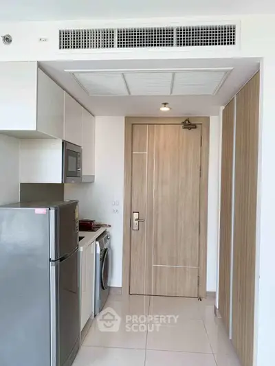 Modern kitchen with sleek appliances and wooden cabinetry in a compact layout.