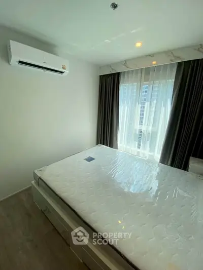 Modern bedroom with air conditioning and large window offering city view