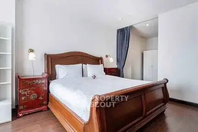 Elegant bedroom with wooden bed frame and stylish decor in modern apartment.