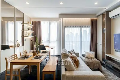 Modern living room with dining area, large windows, and stylish decor in a high-rise apartment.