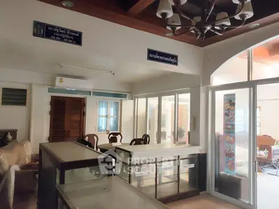 Spacious interior with glass partitions and wooden furniture, ideal for office or retail space.