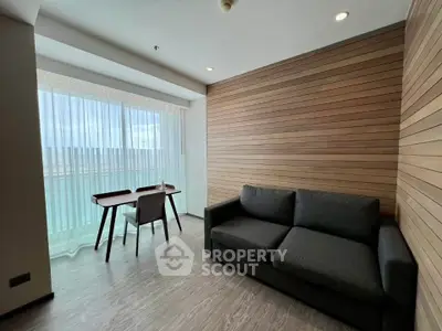 Modern living room with wood paneling, large window, and stylish furniture.