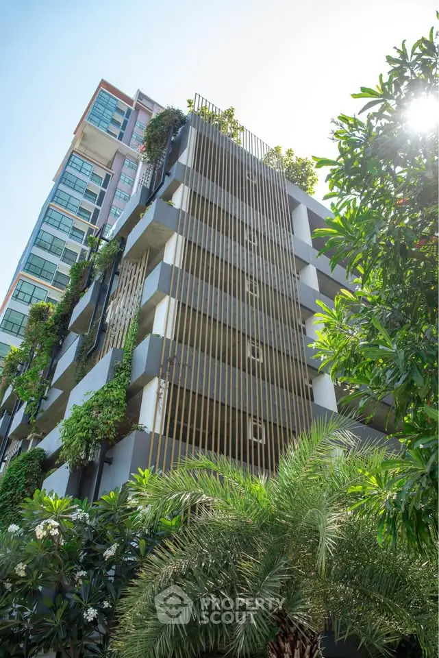 Modern residential building with lush greenery and unique architectural design.