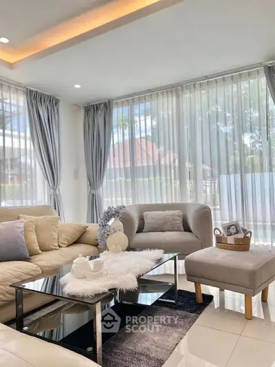 Elegant living room with modern decor and large windows offering natural light.