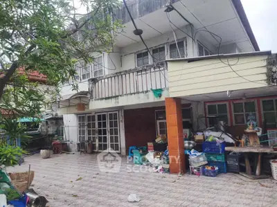 Spacious two-story house with large patio and lush greenery, ideal for renovation and customization.