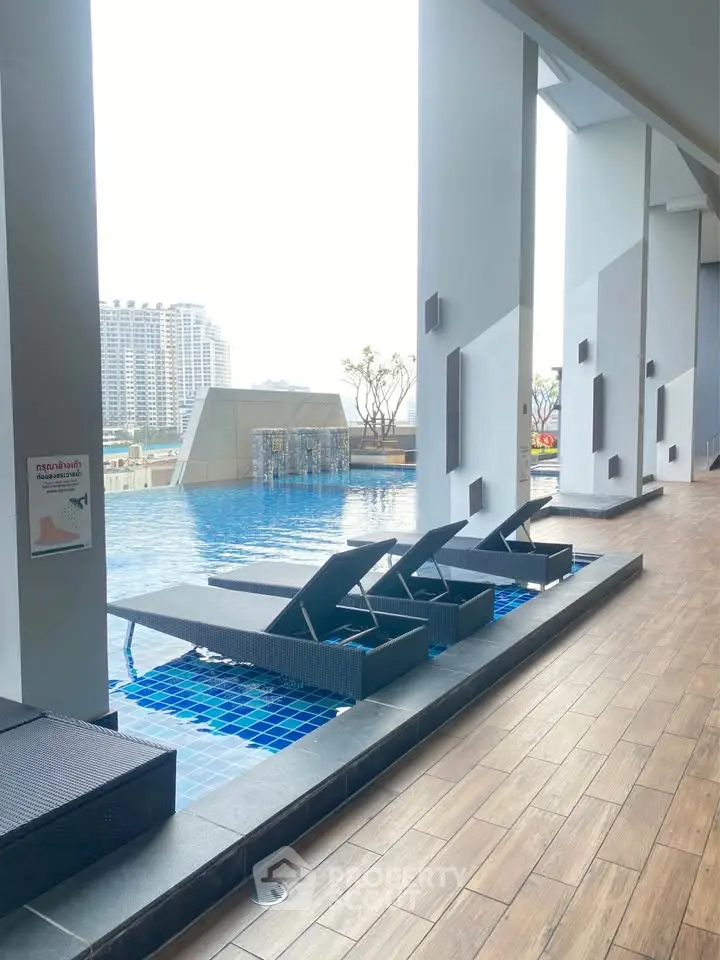 Luxurious rooftop pool with modern lounge chairs and city view