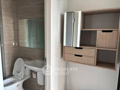 Modern bathroom with sleek fixtures and wooden storage unit, perfect for contemporary living.