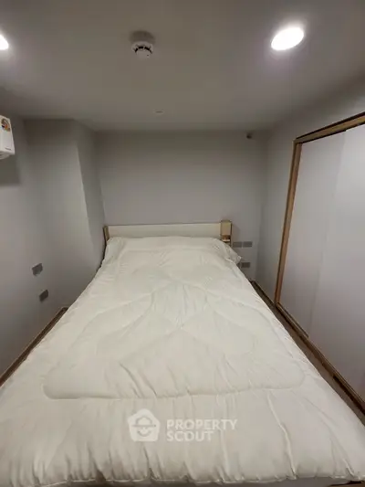 Cozy bedroom with modern lighting and minimalist design, featuring a comfortable bed and ample storage space.