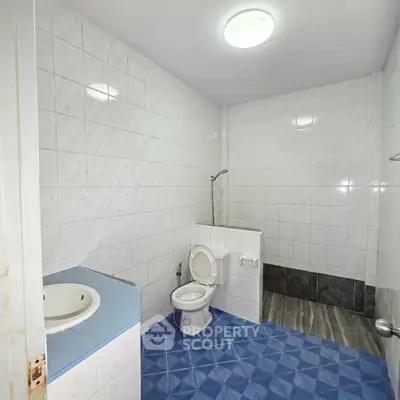 Spacious bathroom with modern fixtures and blue tile flooring