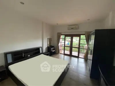 Spacious bedroom with balcony access and modern furnishings