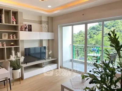 Modern living room with large windows and balcony overlooking lush greenery