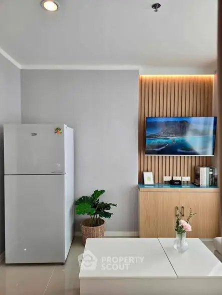 Modern living room with sleek fridge and mounted TV, stylish decor