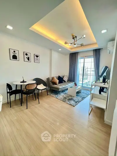 Modern living room with stylish decor and balcony view in a contemporary apartment.